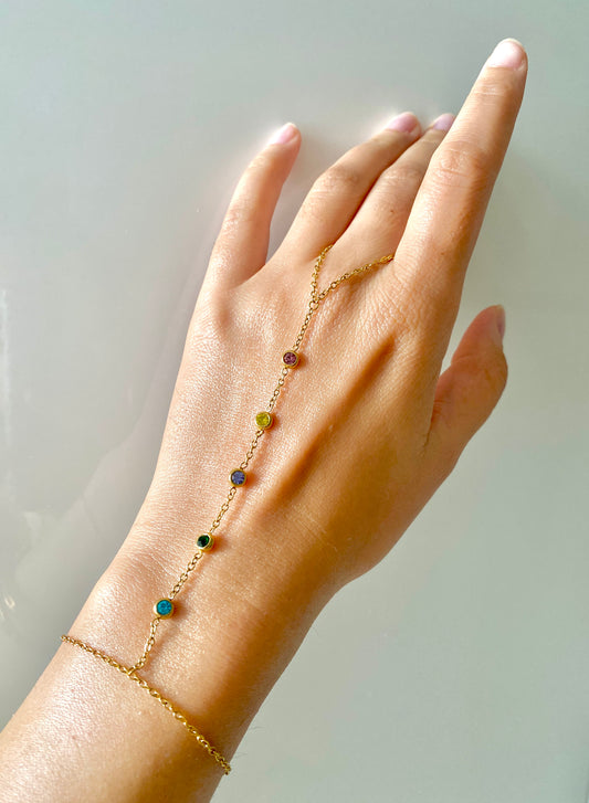 Elegante Handkette mit bunten Steinen, in gold